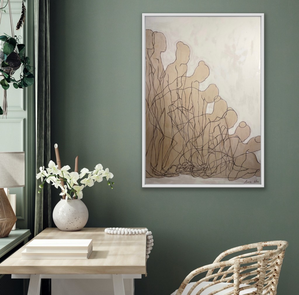 A drawing of overlapping figures hanging on wall above a desk and chair